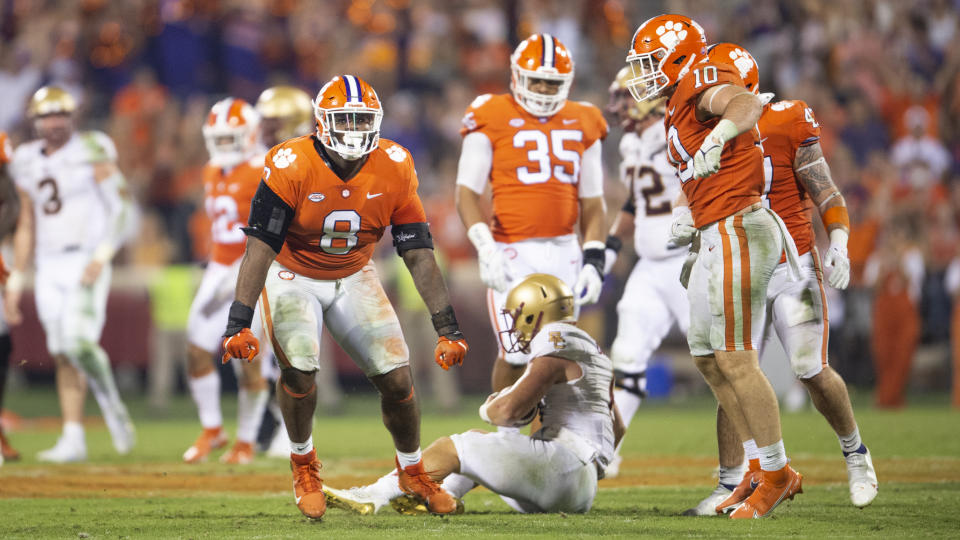 Clemson defensive tackle Tre Williams (8) and linebacker Baylon Spector (10) react after sacking Boston College quarterback Dennis Grosel, bottom center, during the second half of an NCAA college football game Saturday, Oct. 2, 2021, in Clemson, S.C. (AP Photo/Hakim Wright Sr.)