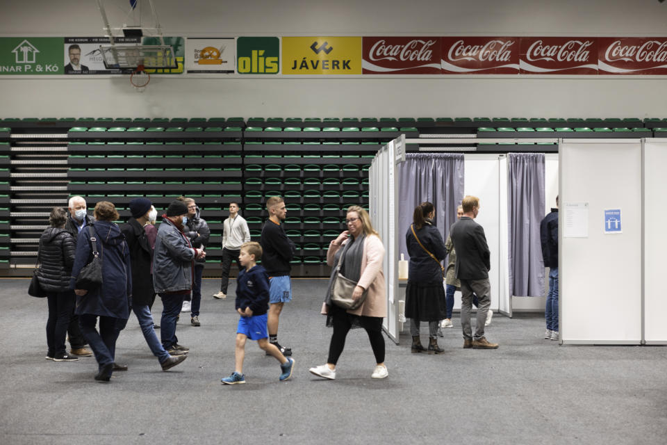 People vote at a local sports complex in Kopavogur, Iceland, Saturday, Sept. 25, 2021. Icelanders are voting in a general election dominated by climate change, with an unprecedented number of political parties likely to win parliamentary seats. (AP Photo/Arni Torfason)