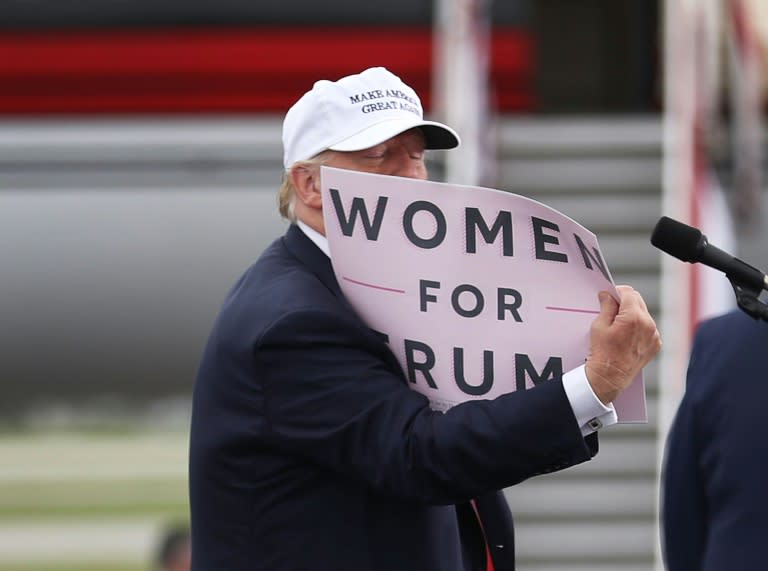 Donald Trump sostiene un cartel en el que se lee 'Mujeres por Trump' durante su campaña presidencial de 2016, salpicada por el escándalo sobre su trato a las mujeres (JOE RAEDLE)