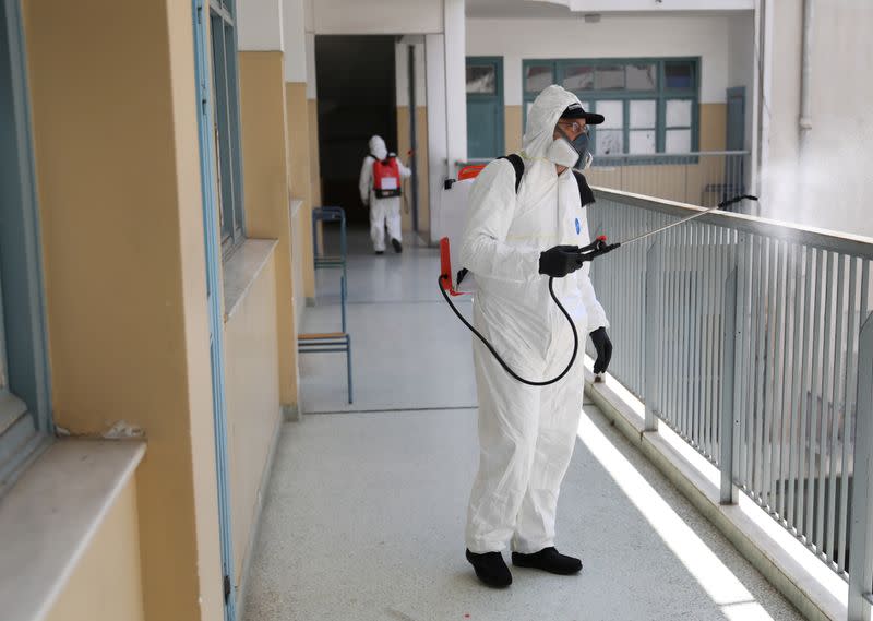 A municipal worker wearing personal protective equipment (PPE) disinfects a school, on the first day of the easing of a nationwide lockdown against the spread of the coronavirus disease (COVID-19), in Athens