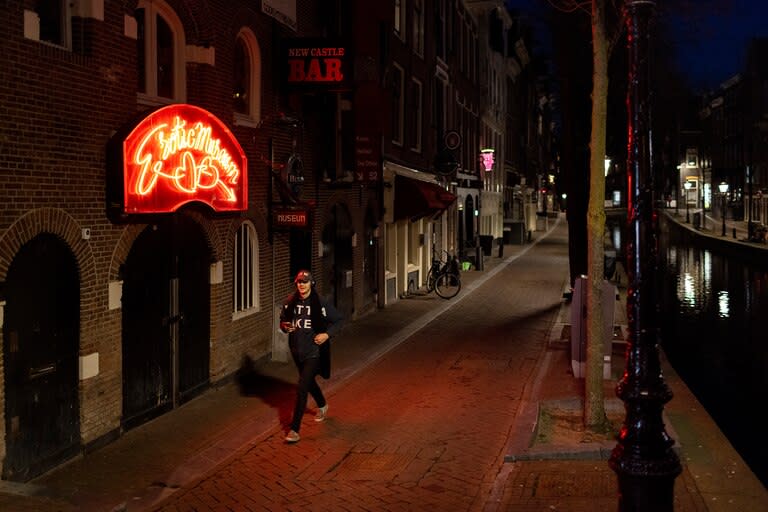 Un hombre camina por el Barrio Rojo casi desierto de Ámsterdam el 25 de marzo de 2021