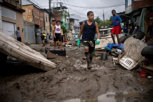 Children walk in the mud following heavy rains during the weekend, in Realengo neighborhood, in the suburbs of Rio de Janeiro, Brazil, on March 2, 2020