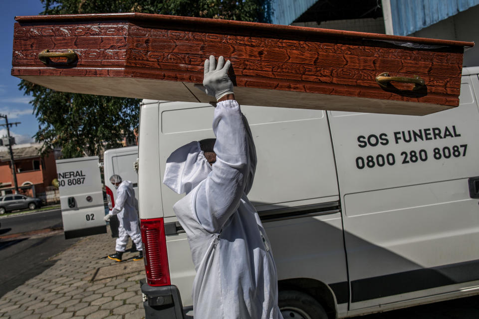 A funeral employee carries a coffin in Manaus.