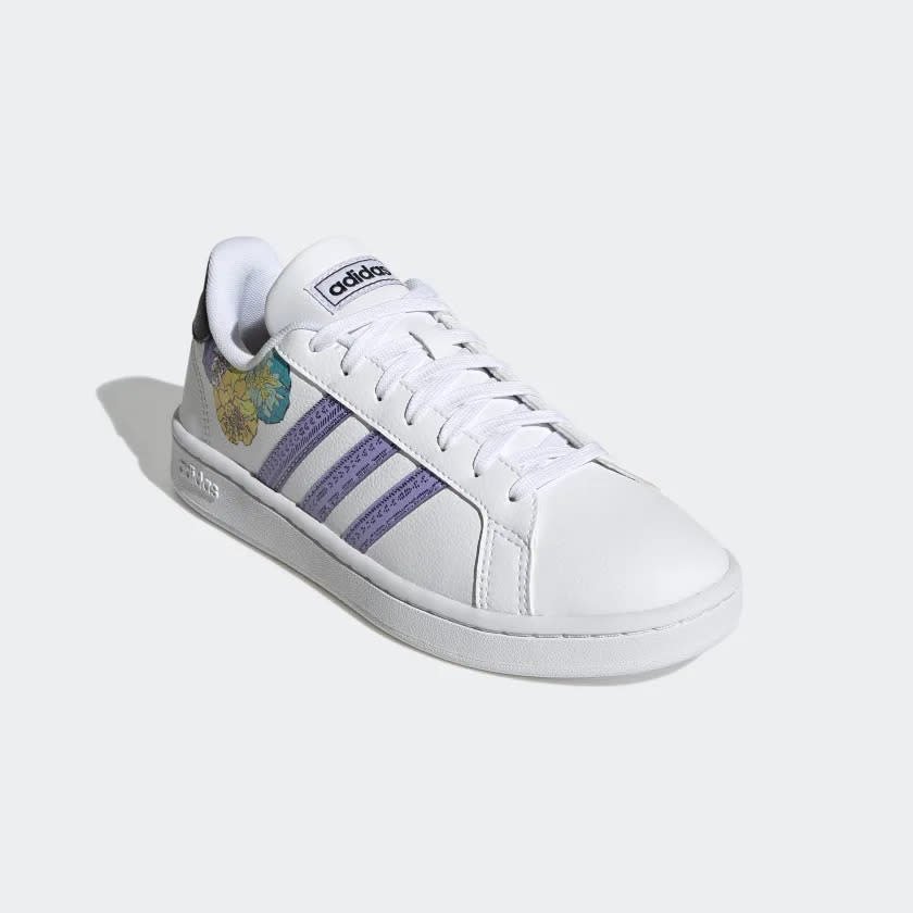 White sneakers with three purple stripes and colorful flowers on the heel.