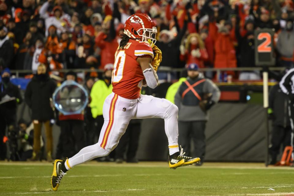 Chiefs running back Isiah Pacheco high-steps with the football.