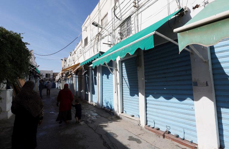 Libyans walk past closed shops in the capital Tripoli at the start of a three-day strike in Tripoli on November 17, 2013