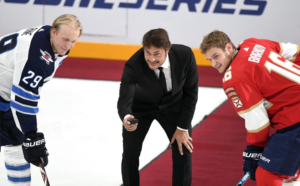 Retired NHL star Teemu Sel'nne drops the ceremonial first puck between Patrik Laine, left, of the Winnipeg Jets and Aleksander Barkov of the Florida Panthers prior the ice hockey NHL Global Series match Florida Panthers vs Winnipeg Jets in Helsinki, Finland on Thursday, November 1, 2018. (Martti Kainulainen/Lehtikuva via AP)