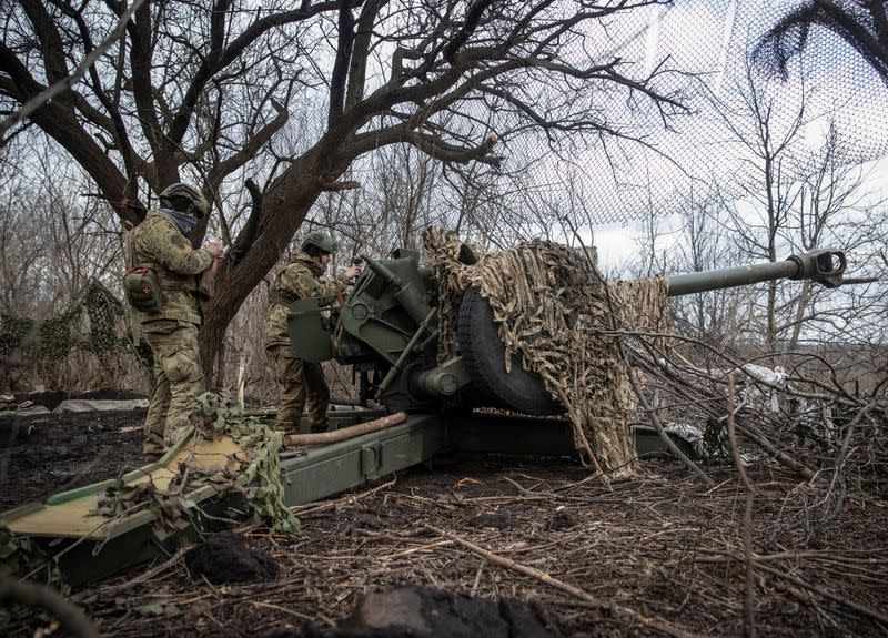 Ukrainian service members prepare to shoot from a howitzer at a front line near the city of Bakhmut