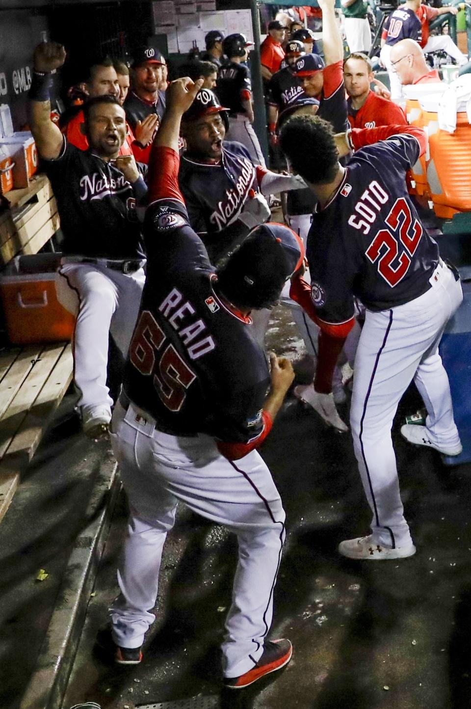 Washington Nationals' Victor Robles celebrates with teammates after hitting a home run during the sixth inning of Game 3 of the baseball National League Championship Series against the Washington Nationals Monday, Oct. 14, 2019, in Washington. (AP Photo/Jeff Roberson)