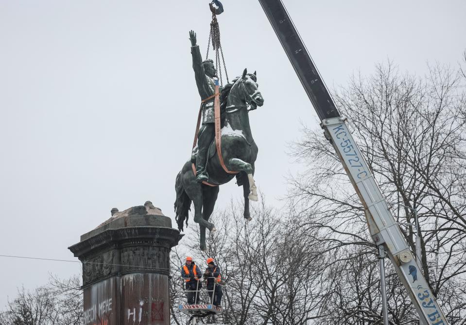 Municipal workers dismount a monument to Mykola Schors, a Soviet field commander during the Russian Civil War, (REUTERS)