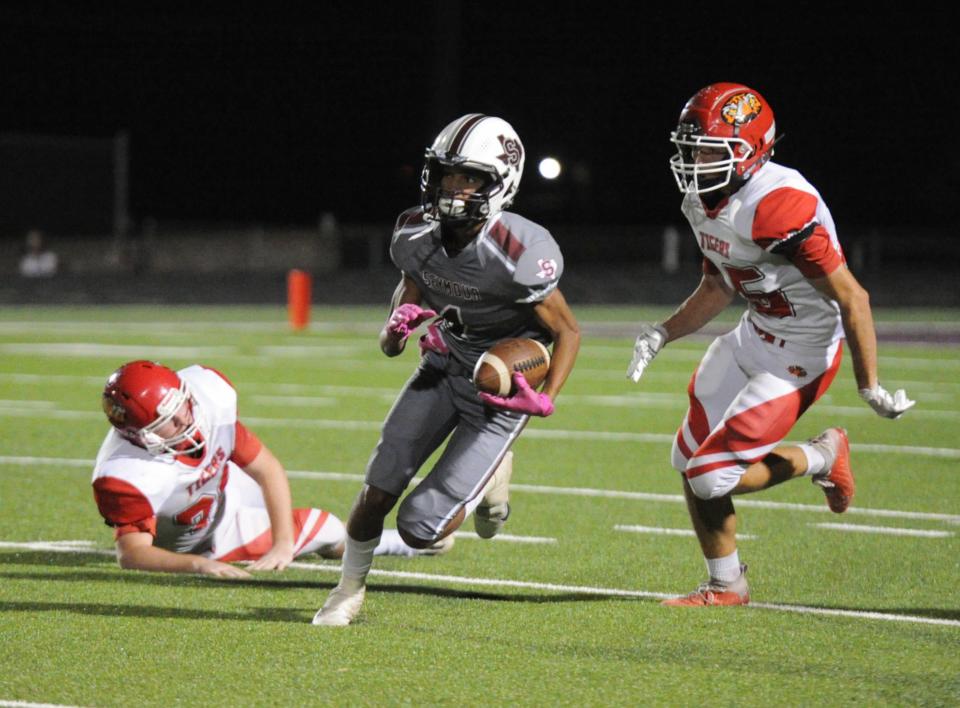 Seymour's Tyler Allbritton runs away from Electra defenders Friday, Oct. 8, 2021, at Fair Park Stadium in Seymour.