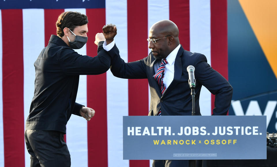 Georgia Democratic Senate candidates Jon Ossoff and Raphael Warnock greet each other onstage during the "Vote GA Blue" concert for Georgia Democratic Senate candidates Raphael Warnock and Jon Ossoff at New Birth Church on December 28, 2020 at New Birth Church in Stonecrest, Georgia. (Paras Griffin/Getty Images)