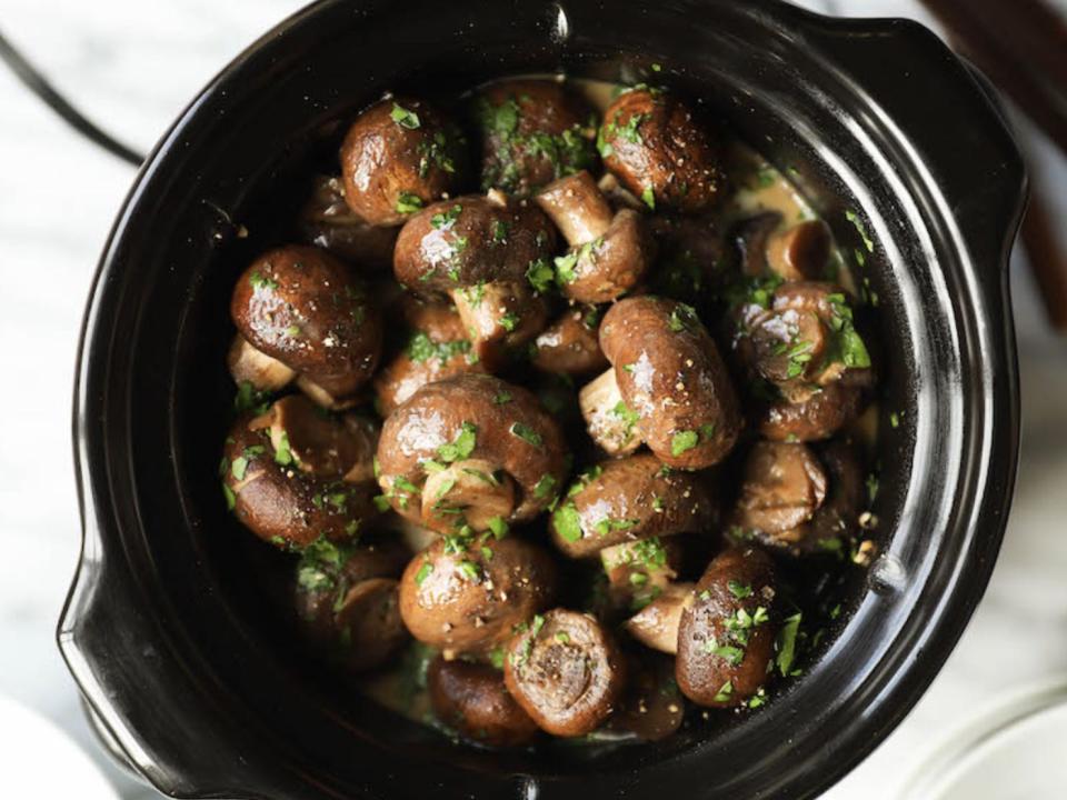 garlic herb mushrooms in a black slow cooker