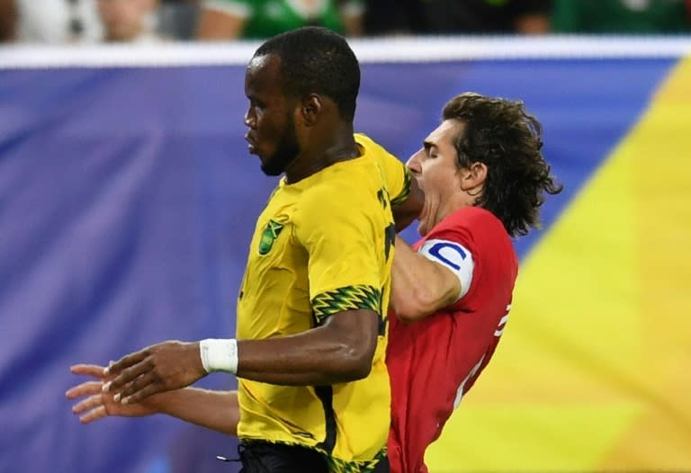 Jamaica's Romario Williams (R) fights for the ball with Dejan Jakovic of Canada during their 2017 CONCACAF Gold Cup quarter-final match, at the University of Phoenix Stadium in Glendale, Arizona, on July 20