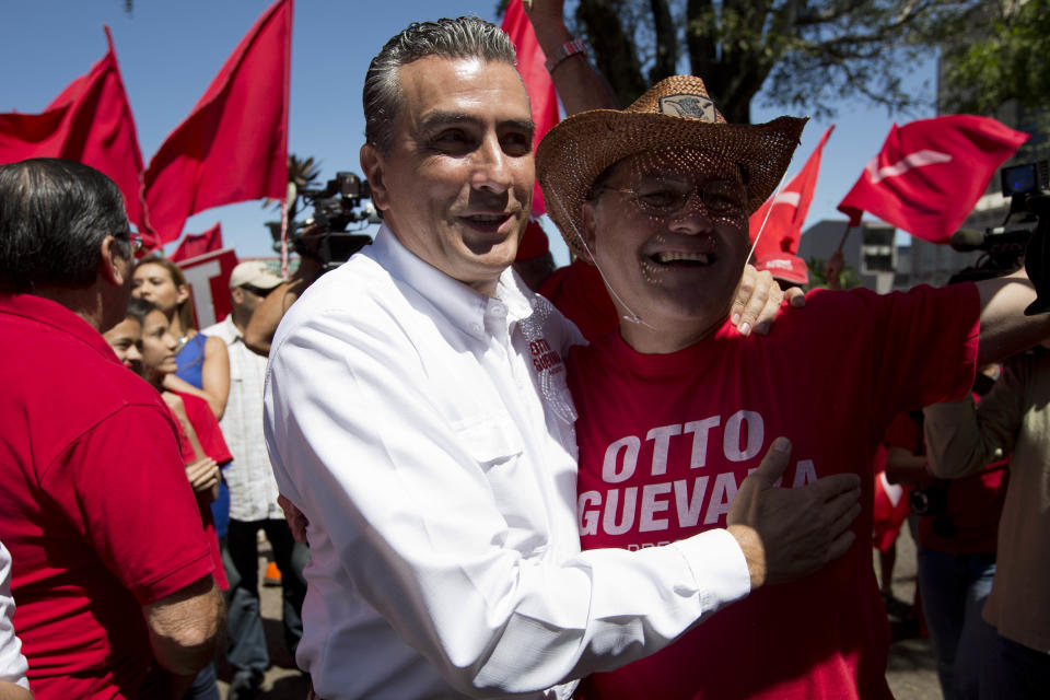 Otto Guevara, candidato presidencial del Partido Movimiento Libertario, izquierda, abraza a un seguidor durante un acto de campaña en San José, Costa Rica, el sábado 1 de febrero de 2014. (Foto AP/Moisés Castillo)