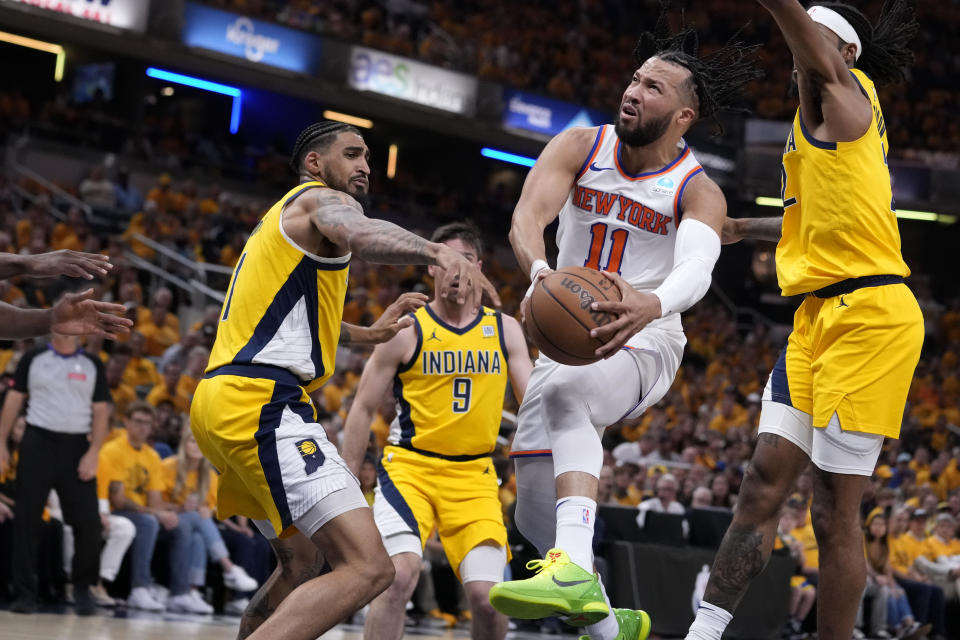 New York Knicks guardı Jalen Brunson (11), 17 Mayıs 2024 Cuma günü Indianapolis'te oynanan NBA play-off serisinin ikinci tur serisinin 6. maçının ilk yarısında soldaki Indiana Pacers forveti Obi Toppin'i geçerek potaya doğru ilerliyor.  (AP Fotoğrafı/Michael Conroy)