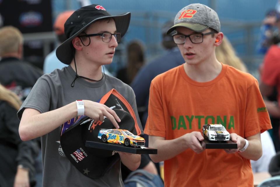 A couple of autograph seekers work through the Fan Zone before the Duels at Daytona on Thursday, February 15, 2024.
