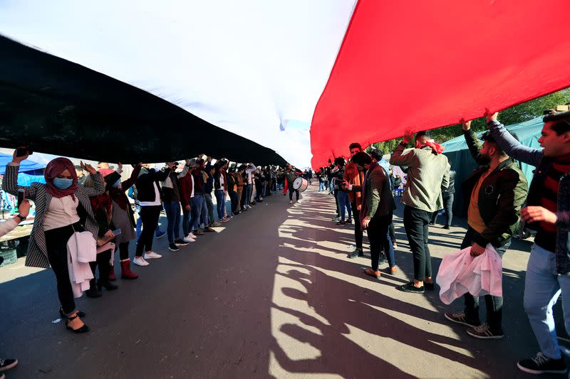 University students carry an Iraqi flag, during ongoing anti-government protests in Baghdad