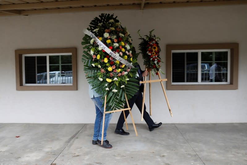 Relatives of Christina Marie Langford Johnson, who was killed by unknown assailants, arrive with flowers during the funeral service before a burial at the cemetery in LeBaron, Chihuahua