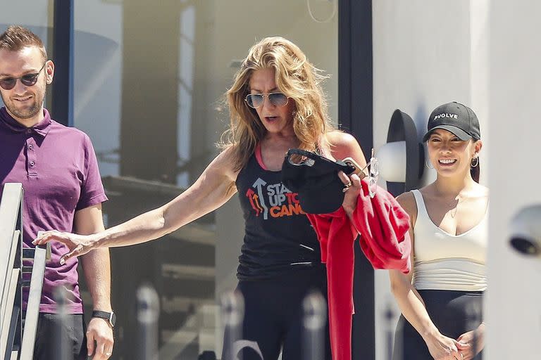 Jennifer Aniston baja las escaleras con cuidado de no tropezar, al salir de una clase de Pilates