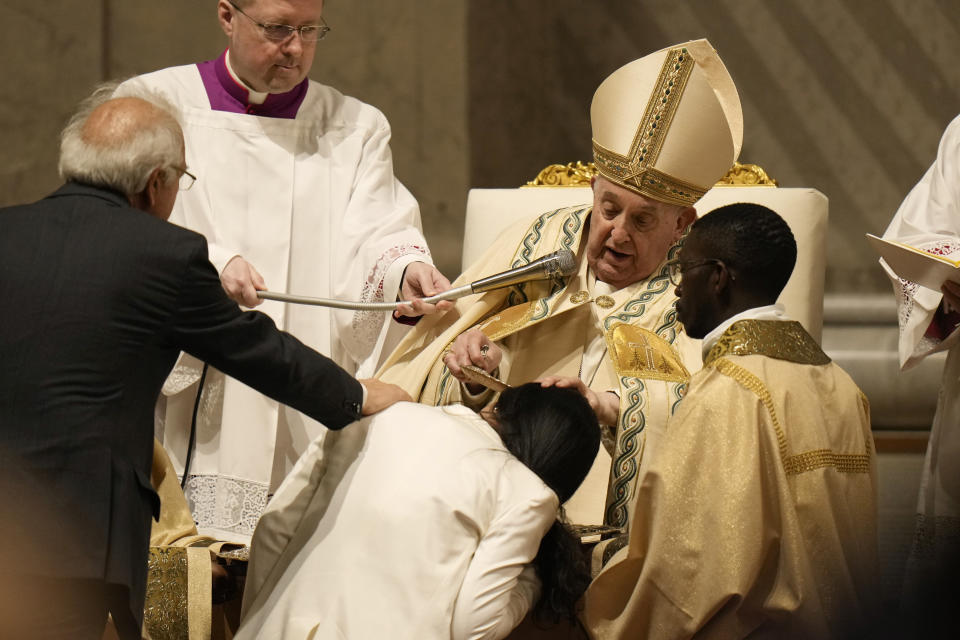 Pope Francis baptises a faithful as he presides over the Easter vigil celebration in St. Peter's Basilica at the Vatican, Saturday, March 30, 2024. (AP Photo/Alessandra Tarantino)