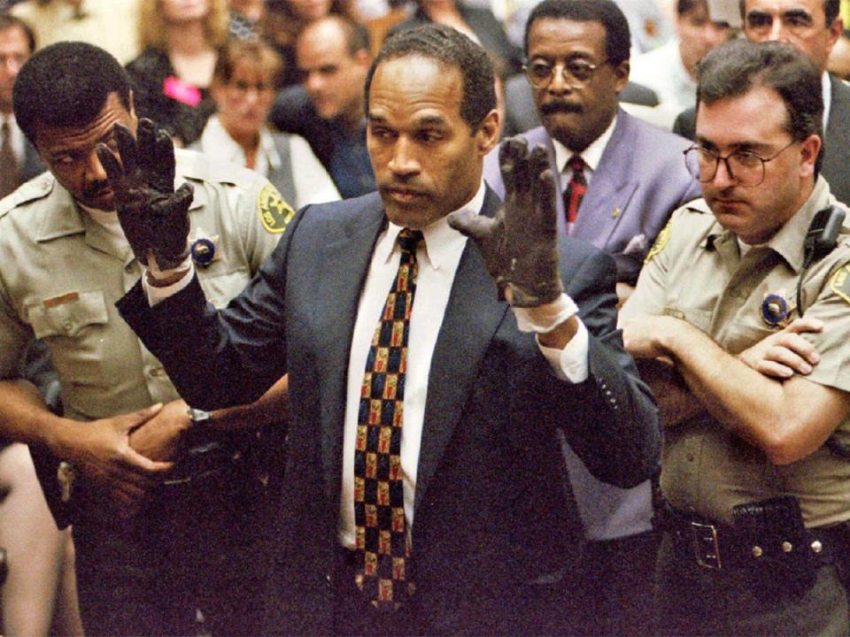 OJ Simpson wears the blood-stained gloves during his murder trial in Los Angeles in 1995 (Reuters)