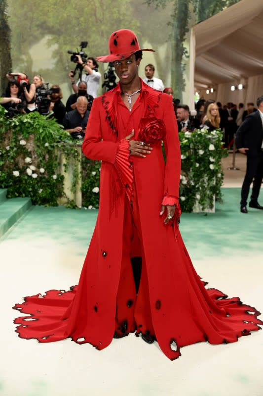 <p>Dimitrios Kambouris/Getty Images</p><p>The model and TikTok star wore a burnt red ensmble including a floor-length jacket and singed hat. </p>