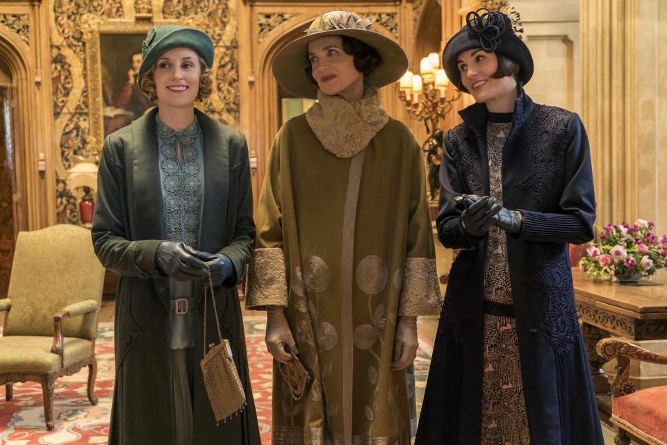 Laura Carmichael, Elizabeth McGovern, and Michelle Dockery dressed in fancy hats and coats on the set of downton abbey