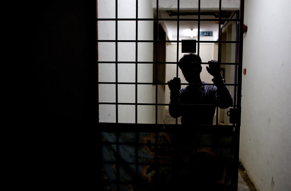 Sayed, a member of Myanmar's long-persecuted Rohingya minority, stands behind a metal door at the entrance of a friend's house in peninsular Malaysia on Monday, April 1, 2019. Sayed is part of an invisible workforce, made up of millions of poor laborers from across Asia, many of whom face exploitation and abuse in both Malaysia and neighboring Indonesia. Together, the two countries produce an estimated 85 percent of the world's $65 billion palm oil supply. (AP Photo/Gemunu Amarasinghe)