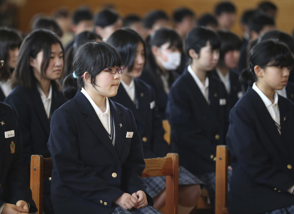 In this Saturday, April 5, 2014 photo, Kokoro Kamiyama, 13, left in foreground, attends an opening ceremony of her Aida junior high school as she starts her new life in Matsumoto, central Japan, after moving from Fukushima. Kamiyama is the first child to sign on to the Matsumoto project which Chernobyl-doctor-turned-mayor Akira Sugenoya of Matsumoto, offered his Japanese town to get children out of Fukushima. Kamiyama was prone to skipping school when she was in Fukushima, which her mother believes was a sign of stress from worrying about radiation. She is happy she can run around outdoors in the city without wearing a mask. “The air feels so clean here,” Kamiyama said. (AP Photo/Koji Sasahara)