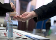A man washes his hands during the first round of the municipal elections, in Lille, northern France, Sunday March 15, 2020. France is holding nationwide elections Sunday to choose all of its mayors and other local leaders despite a crackdown on public gatherings because of the new virus. For most people, the new coronavirus causes only mild or moderate symptoms. For some it can cause more severe illness. (AP Photo/Michel Spingler)