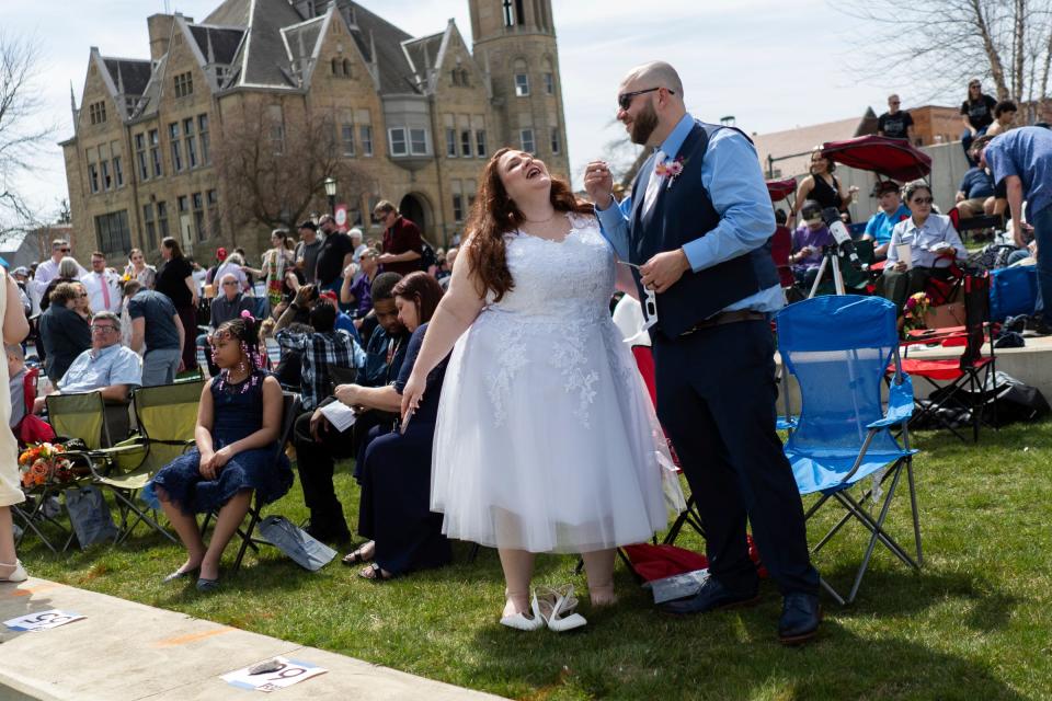 Destiney Stagner, of Richmond, Ky., and her husband, Brad Stagnerr, of Richmond, Ky., dance as a DJ plays music while waiting with others to get married during the Elope at the Eclipse event at the Frost Kalnow Amphitheater in Tiffin, Ohio, on Monday, April 8, 2024. Over 100 couples and their families gathered to be married or renew their vows during the totality of the eclipse event.