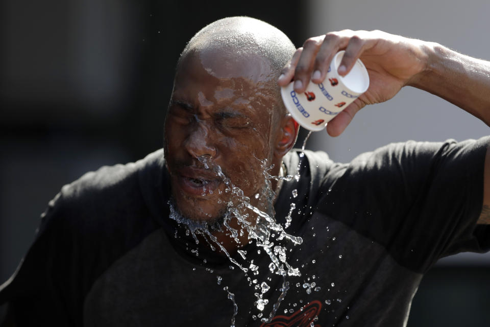 Baltimore Orioles outfielder Keon Broxton douses himself with water while taking a break between fielding and batting practice prior to a baseball game against the Boston Red Sox, Friday, July 19, 2019, in Baltimore. A heat wave is hitting Baltimore and heat advisories have been set ahead of a hot weekend. (AP Photo/Julio Cortez)