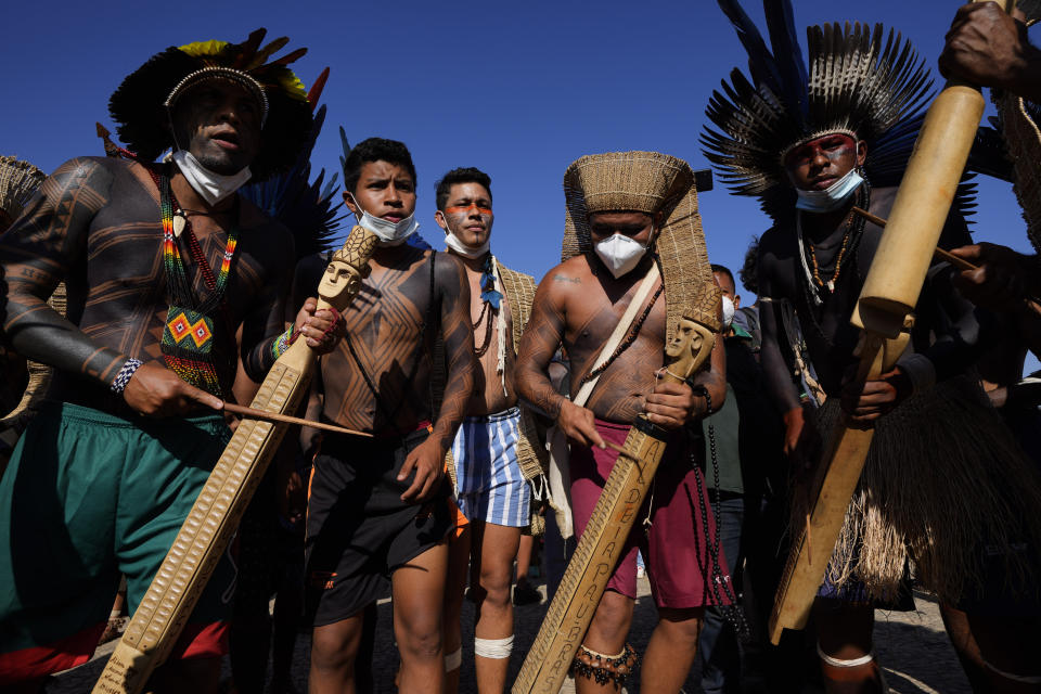 Indigenous men perform a ritual during the "Luta pela Vida," or Struggle for Life mobilization, a protest to pressure Supreme Court justices who are expected to issue a ruling that will have far-reaching implications for tribal land rights, outside the Supreme Court in Brasilia, Brazil, Wednesday, Aug. 25, 2021. (AP Photo/Eraldo Peres)