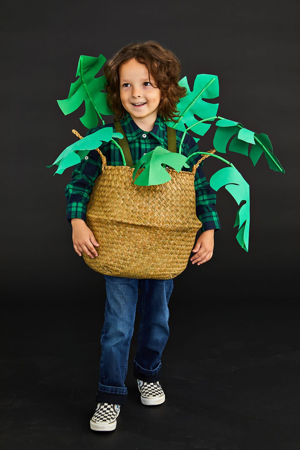 <p>It's not so hard to transform into the perfect houseplant.<br></p><ol><li>Cut a hole in the bottom of a grasscloth basket wide enough for wearer’s hips and legs to fit through comfortably.</li><li>Download the <a href="https://www.goodhousekeeping.com/holidays/halloween-ideas/a33564450/gh-halloween-artwork-calligraphy-templates/" rel="nofollow noopener" target="_blank" data-ylk="slk:leaf template;elm:context_link;itc:0;sec:content-canvas" class="link ">leaf template</a> and trace it onto green paper. Trim and fold in half.</li><li>Cut varying lengths of wire. </li><li>Create stems by threading wire through green straws, dabbing hot glue as you thread to keep straws in place.</li><li>Hot-glue leaves to ends of stems.</li><li>Hot-glue stems to inside of basket, avoiding sides. Reinforce with duct tape if necessary once dry. </li><li>Cut 2 lengths of green ribbon for shoulder straps. Attach to inside front and back of basket with Velcro tape or safety pins.</li><li>With wearer dressed in green; slide basket over head, straps resting on shoulders. </li><li>Bend stems around wearer to create a natural look.</li></ol>