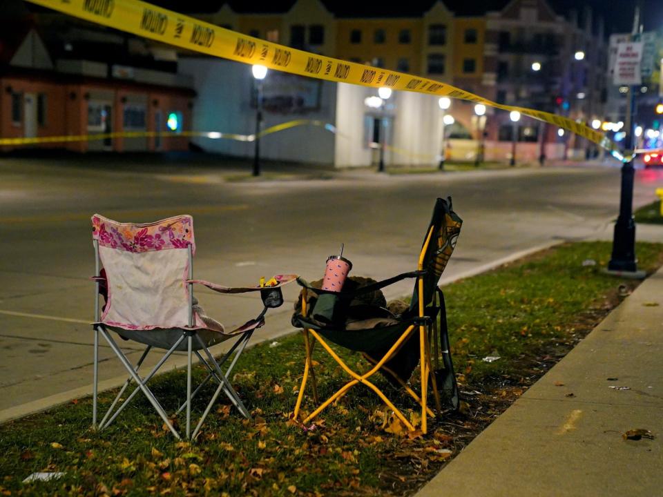 A yellow police cordon and two camping seats by the side of the road in the aftermath of the incident at Waukesha Christmas Parade