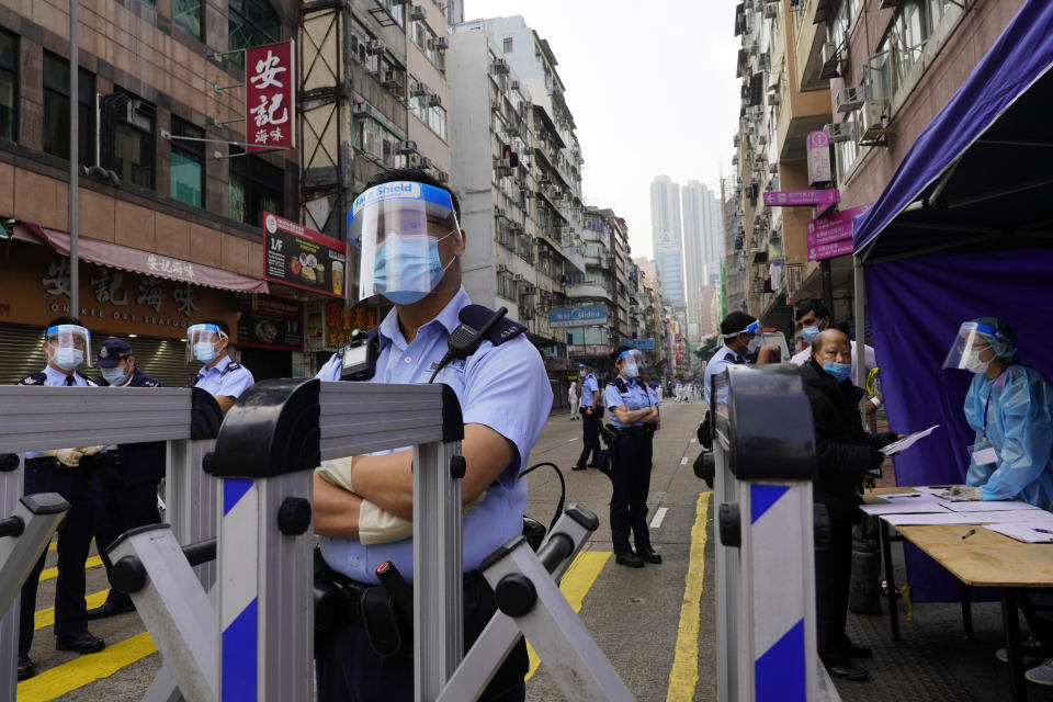 Police officers stand guard at the Yau Ma Tei area in Hong Kong, Saturday, Jan. 23, 2021. Thousands of Hong Kong residents were locked down Saturday in an unprecedented move to contain a worsening outbreak in the city, authorities said. (AP Photo/Vincent Yu)