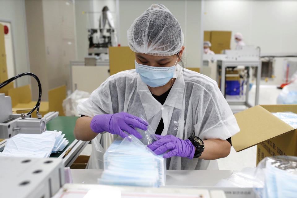 A worker packs surgical masks on the production line in a factory in Taoyuan, Taiwan April 6, 2020. REUTERS/Ann Wang