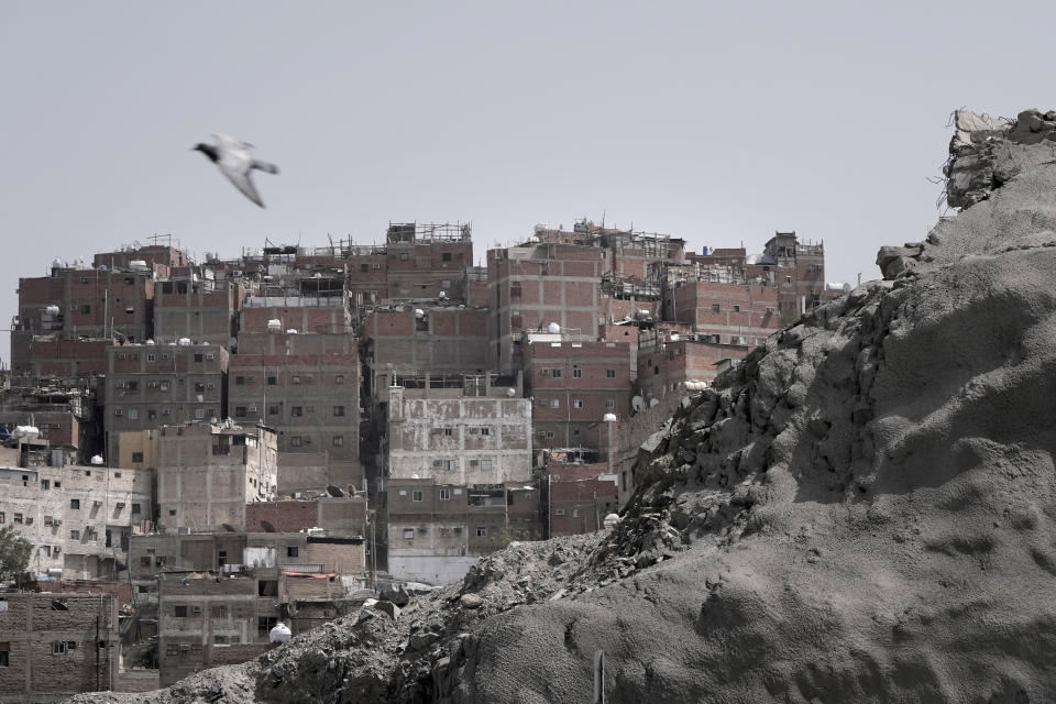 A pigeon flys over slums which on plan to be demolished to make way for towers in the Muslim holy city of Mecca, Saudi Arabia, Sunday, June 25, 2023. Saudi Arabia is pumping billions of dollars into the holy city of Mecca to meet its ambitious economic targets, with high-end hotels, apartment blocks, retailers and restaurants planned for areas around the Grand Mosque. (AP Photo/Amr Nabil)