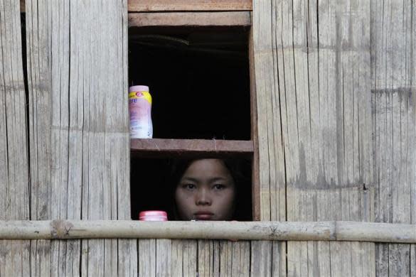 A child watches a ceremony outside her window during the 63rd anniversary of Karen Revolution Day at Oo Kray Kee Township in the Karen State, along the Thai-Myanmar border, January 31, 2012.