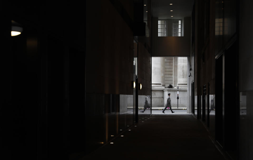 A man walks past the Royal Exchange in London, Tuesday, April 6, 2021. When the pandemic struck, about 540,000 workers vanished from London's financial hub almost overnight. The area known as "the City" became a ghost town as many people began working from home. A year on, most haven't returned to the business hub. While many people believe that post-pandemic workflow will become the new normal, skyscrapers are still rising, and city planners say they aren't worried about empty office blocks. (AP Photo/Alastair Grant)