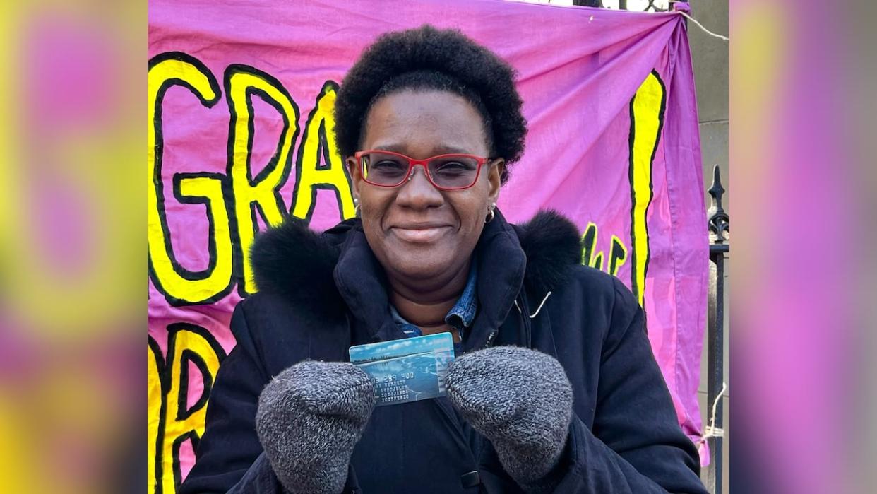 Kerian Burnett, a migrant worker from Jamaica who was diagnosed with cervical cancer while working on a farm in Nova Scotia in 2022, is shown holding her newly issued Nova Scotia health card.  (Paul Palmeter/CBC - image credit)