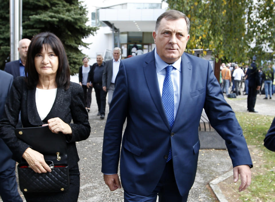 President of the Republic of Srpska Milorad Dodik, right, and his wife Snjezana leave a polling station after voting in Laktasi, northwest of Sarajevo, Bosnia, Sunday, Oct. 7, 2018. Bosnians were voting Sunday in a general election that could install a pro-Russian nationalist to a top post and cement the ethnic divisions of a country that faced a brutal war 25 years ago. (AP Photo/Darko Vojinovic)
