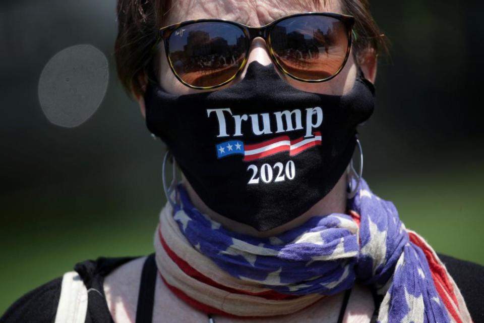 A protestor wears a Trump face mask while rallying against the coronavirus restrictions in Pennsylvania.