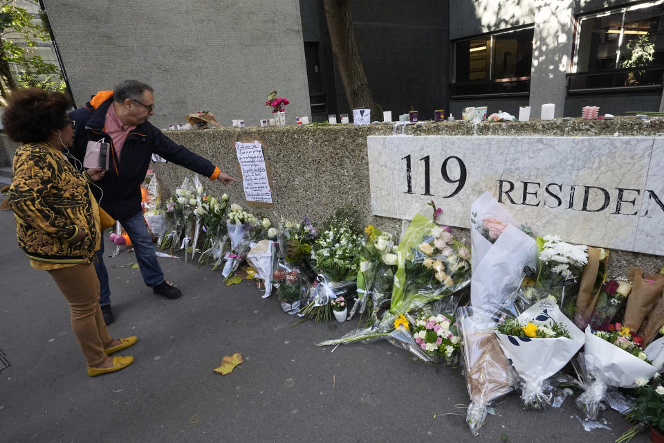 People stand outside the building where the body of 12-year-old schoolgirl was discovered in a trunk, in Paris, Wednesday, Oct. 19, 2022. France has been "profoundly shaken" by the murder of a 12-year-old schoolgirl, whose body was found in a plastic box, dumped in a courtyard of a building in northeastern Paris, the government spokesman Olivier Veran said on Wednesday. (AP Photo/Michel Euler)