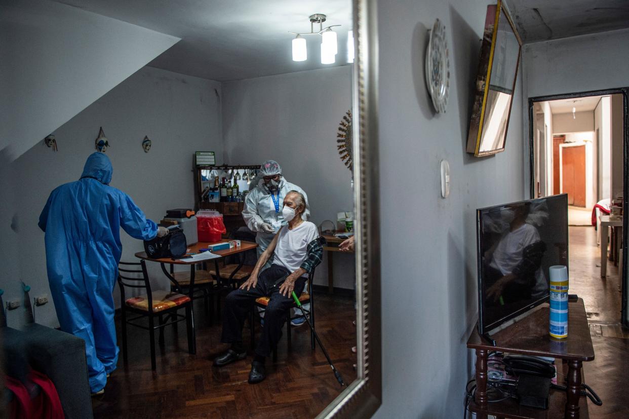 Health workers prepare to give Antonio Ferrari (92) a dose of the Pfizer-BioNTech COVID-19 vaccine at his house in Lima on March 8, 2021, as Peru starts vaccination of the elderly, police and military.