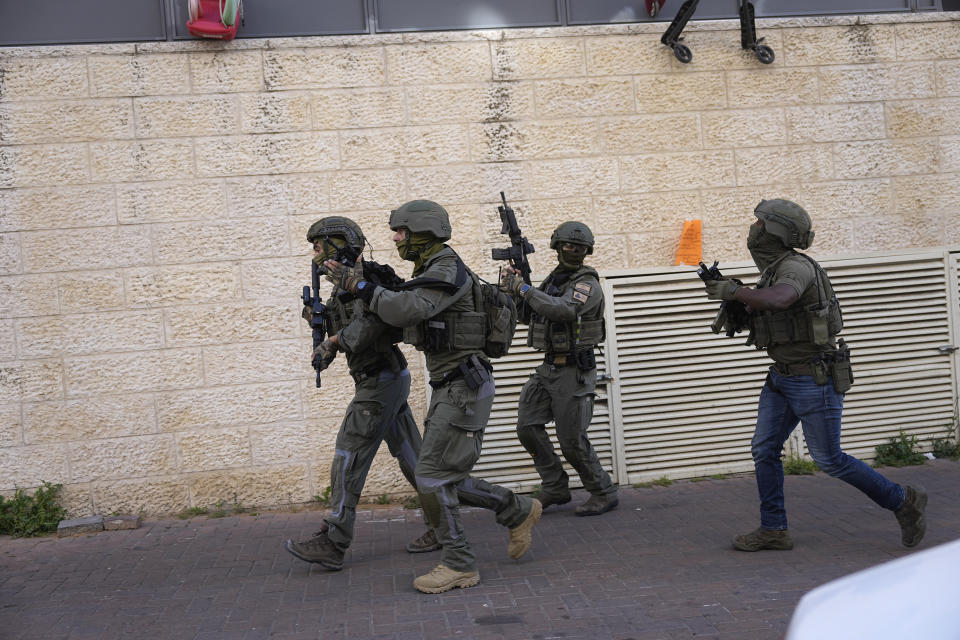 Israeli forces pursue suspected attackers in a ramming attack that wounded three people on the eve of the Jewish holiday of Passover, in Jerusalem, Monday, April 22, 2024. Israeli police say a car slammed into pedestrians in Jerusalem on Monday, wounding three people lightly in an apparent attack. The three were injured when a car ran them over in the neighborhood of Romema, northeast of the city center. Police said they were searching for the two attackers, who they said had exited the vehicle with a submachine gun and fled the scene. (AP Photo/Ohad Zwigenberg)