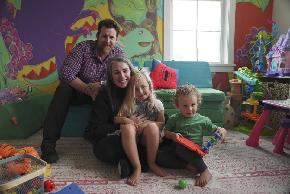 From left, Justin Fell and Katie Czajkowski-Fell sit for a photo with their children, Leonore and Cameron, at home in Bel Air, Md., on Dec. 4, 2023. “I thought he would be fine and it was just a matter of letting this run its course,” says Justin, explaining how multiple doctors told the family not to worry whenever their late son, Hayden, had a fever-sparked seizure. Instead, “it was every parent’s nightmare.” (AP Photo/Shelby Lum)