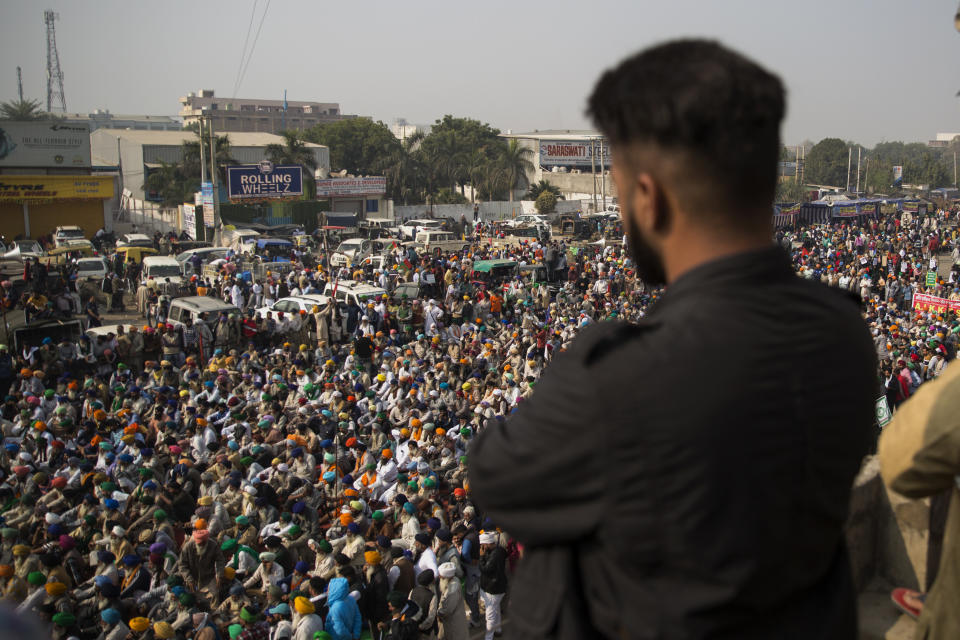 Protesting farmers listen to a speaker as they block a major highway against new farming laws they say will result in exploitation by corporations, eventually rendering them landless, at the Delhi-Haryana state border, India, Tuesday, Dec. 1, 2020. The busy, nonstop, arterial highways that connect most northern Indian towns to this city of 29 million people, now beat to the rhythm of never-heard-before cries of "Inquilab Zindabad" ("Long live the revolution"). Tens and thousands of farmers, with colorful distinctive turbans and long, flowing beards, have descended upon its borders where they commandeer wide swathes of roads. (AP Photo/Altaf Qadri)