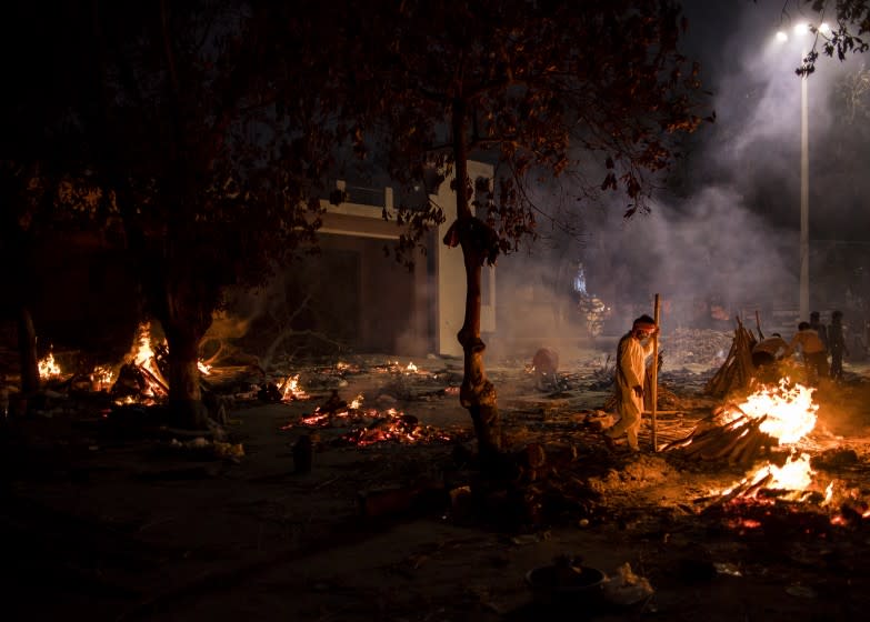 NEW DELHI, INDIA - APRIL 29: Workers can be seen at a crematorium where multiple funeral pyres are burning for patients who lost their lives to Covid-19 on April 29, 2021 in New Delhi, India. With recorded cases crossing 380,000 a day and 3000 deaths in the last 24 hours, India has more than 2 million active cases of Covid-19, the second-highest number in the world after the U.S. A new wave of the pandemic has totally overwhelmed the country's healthcare services and has caused crematoriums to operate day and night as the number of victims continues to spiral out of control. (Photo by Anindito Mukherjee/Getty Images)